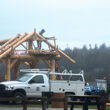 Workers construct a log pavilion