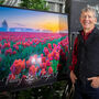 Gary Brown stands next to large tulip festival 2024 poster.
