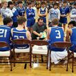 Coach talks to basketball players in a huddle
