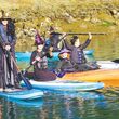 People dressed as witches and warlocks on paddleboards.
