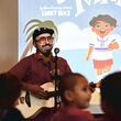 Author and musician Lucky Diaz plays guitar for children