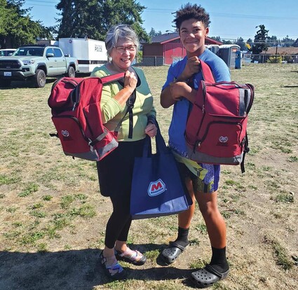 Lona Wilbur and Quentin Cobbs holding emergency preparedness backpacks.