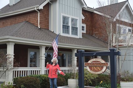 A woman stands outside the Saratoga Inn