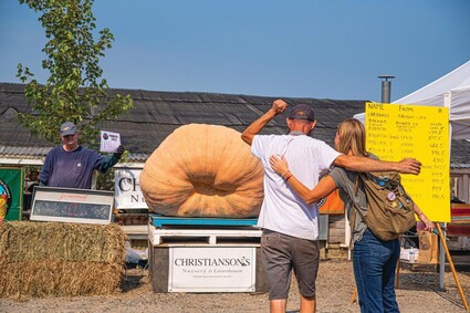 The winner and his sister look at winning pumpkin.