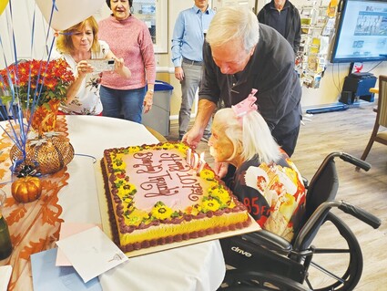 107 year old Trudy Newton blows out candles on her cake.