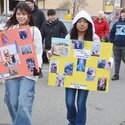 Two girls carry posters with photos of pets