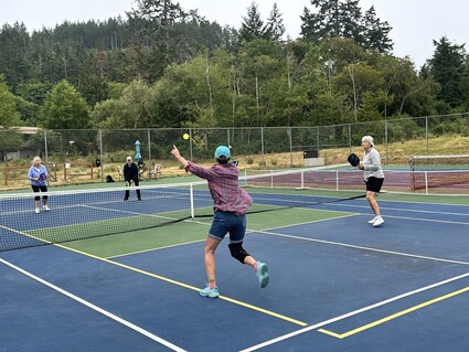 Four people play pickleball