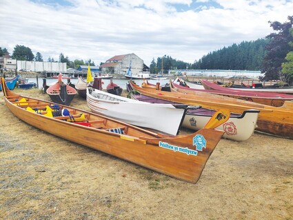 Traditional Native American canoes are shown on a beach