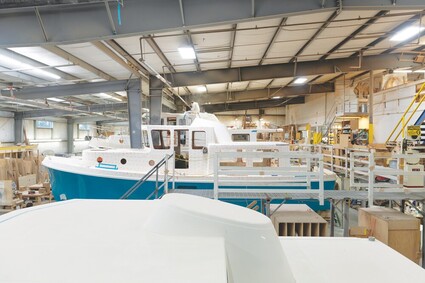 Image of boats in line in various stages of being built.