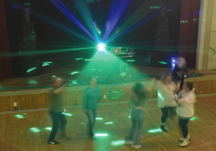 Green light shines on people dancing on St. Patrick's Day